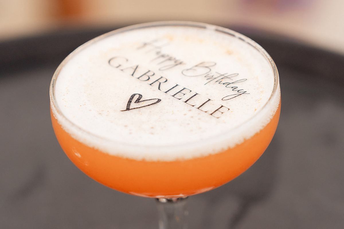 A custom cocktail with Gabrielle's name printed in the foam.