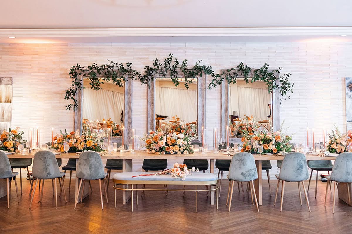 Head table with floral arrangements, lounge seating, and vintage-inspired reception details.