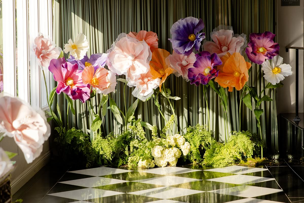 Colorful floral installation along a black-and-white checkered floor.