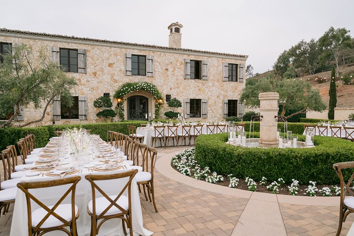 Long-table place settings with woven chargers, white plates, and neutral details.