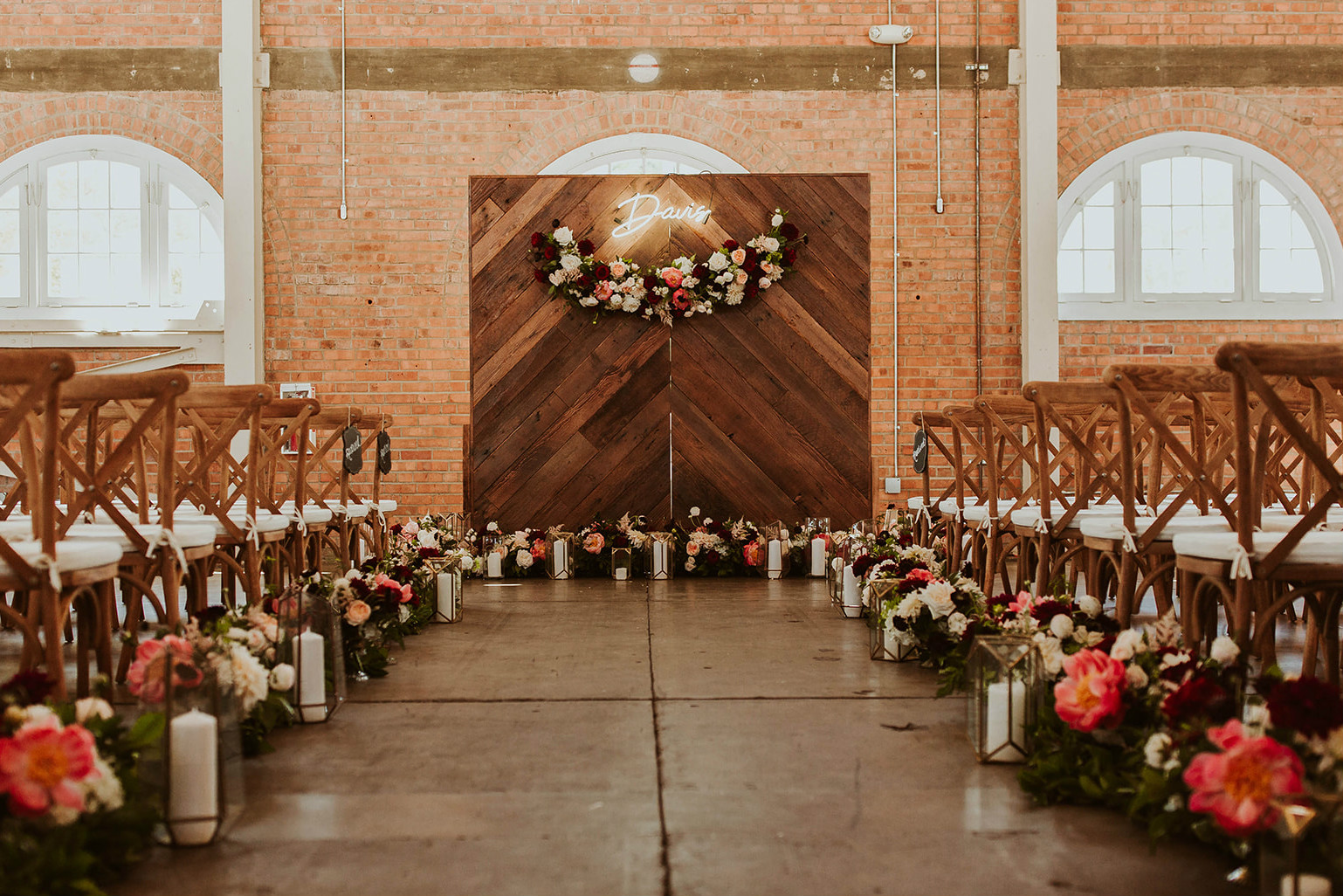 Wedding ceremony setup with bright flowers and wood accents
