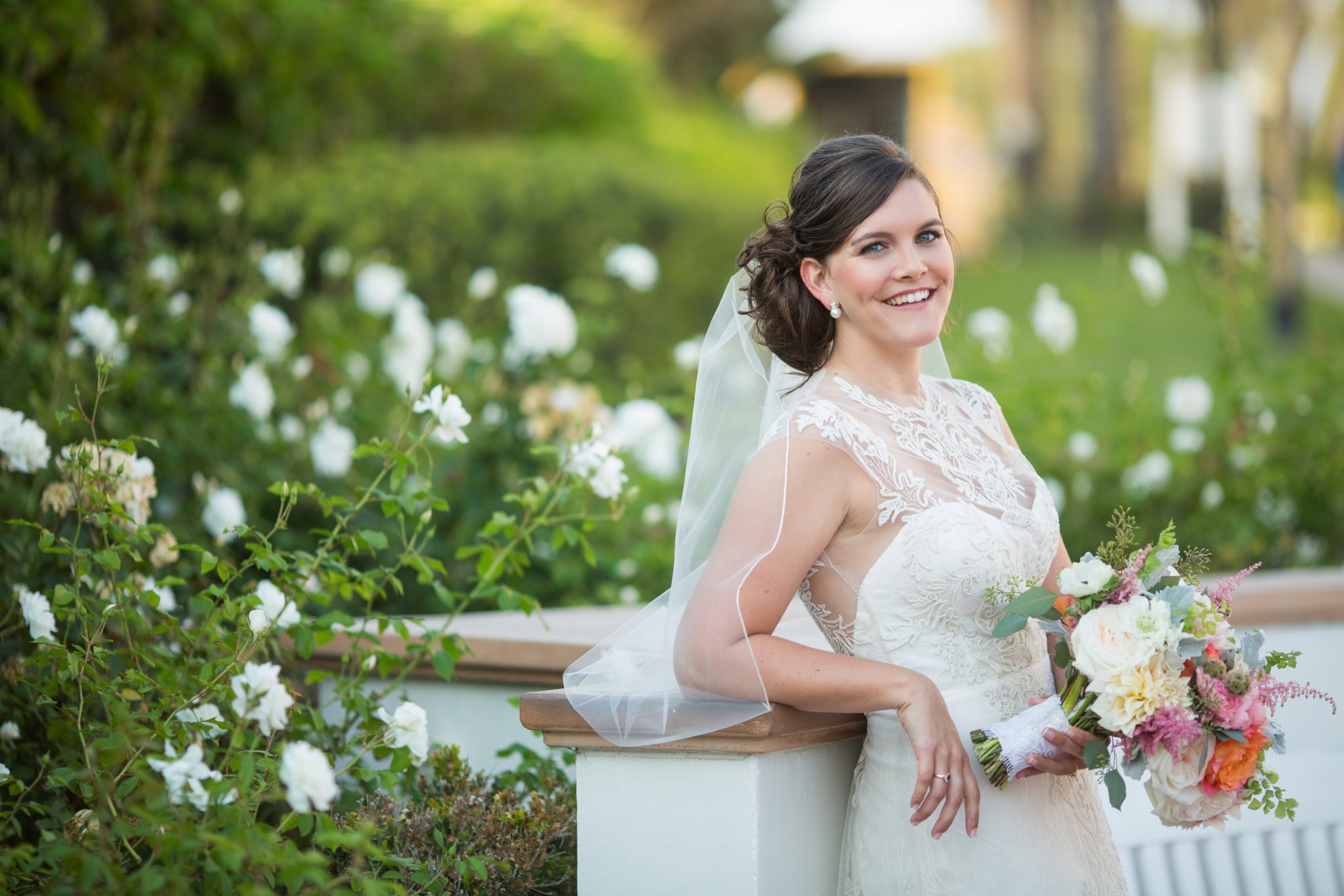 Beautiful bride posing in a white gown and floral bouquet
