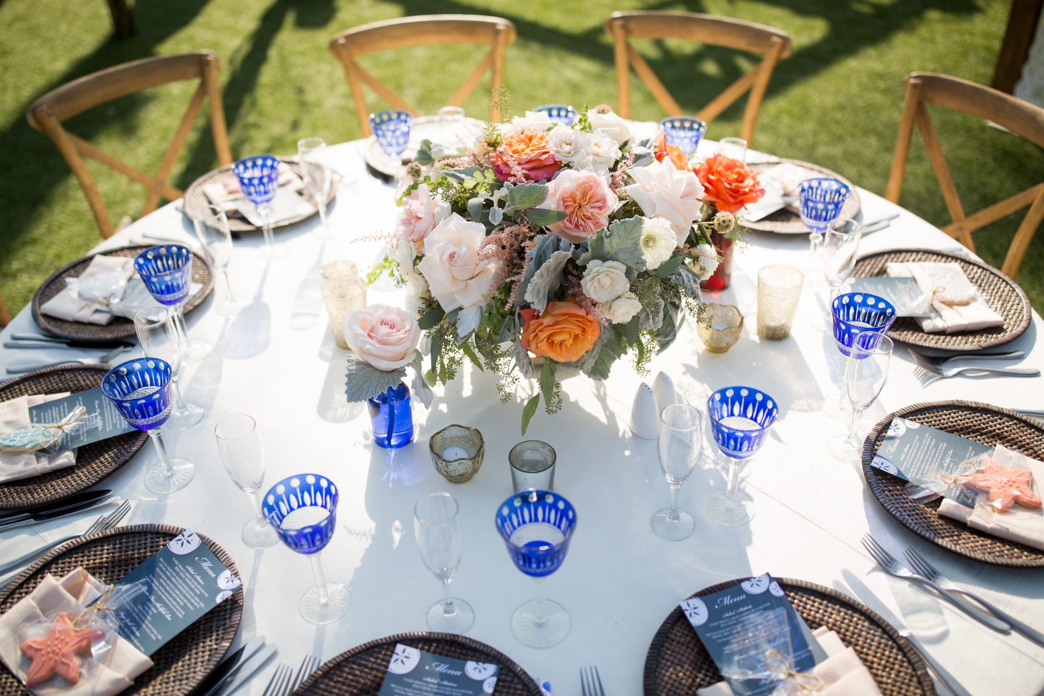 Wonderful place setting with blue glasses and a nice floral centerpiece